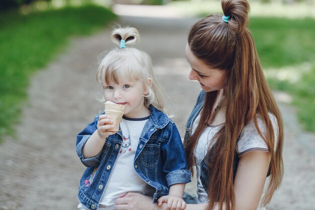 Mother looking at her daughter while eating an ice cream