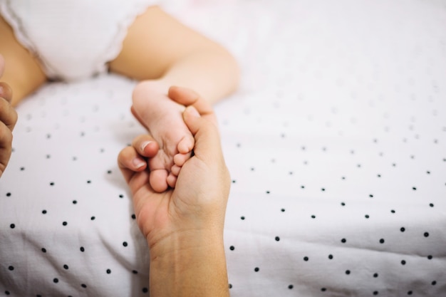 Madre che massaggia i piedi del bambino