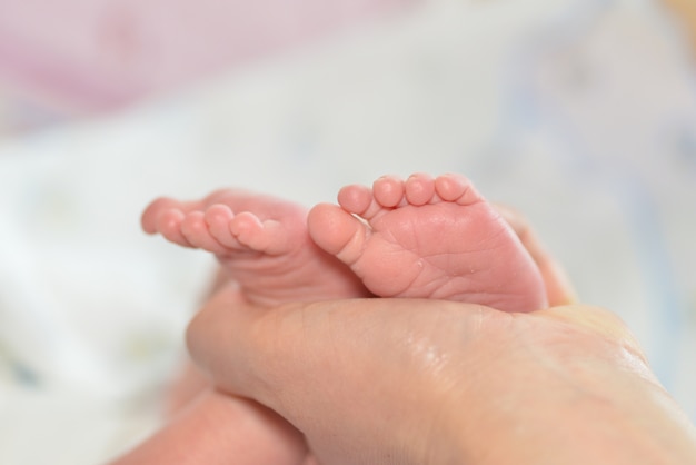 Mother massaging her child's foot, shallow focus