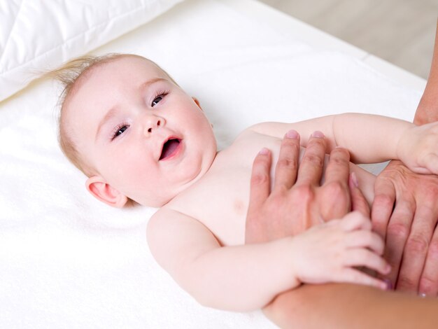 Mother massaging of newborn baby