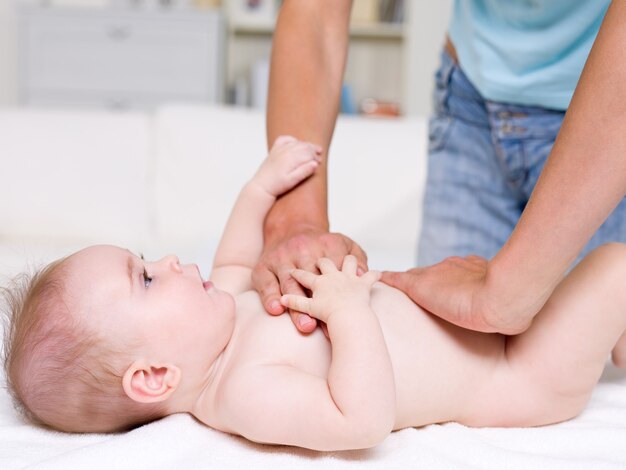 Mother massaging of newborn baby