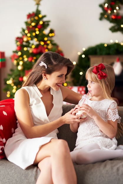 Mother passing bottle of milk to daughter