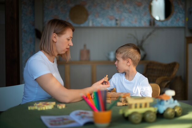 おもちゃを使って自閉症の息子と遊ぶ母親