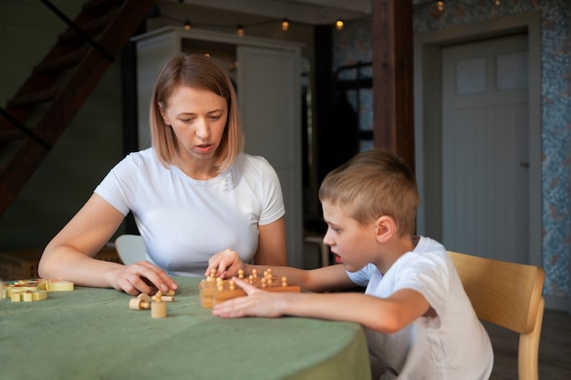 Mother playing with her autistic son using toys