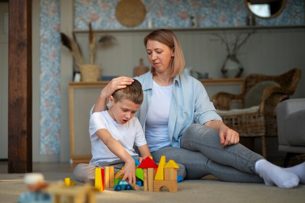 おもちゃを使って自閉症の息子と遊ぶ母親