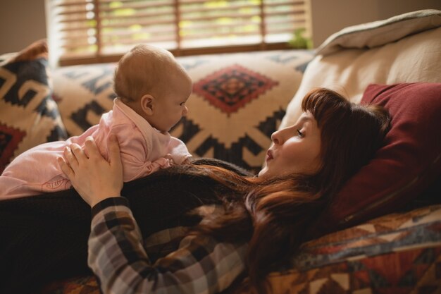 Mother playing with her baby on sofa