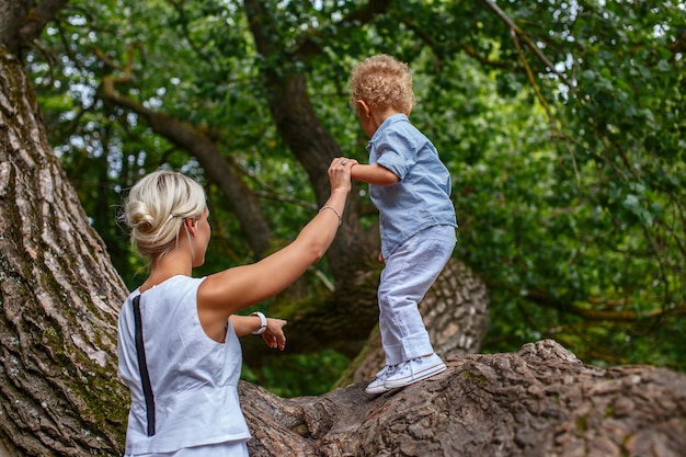 공원에서 나무에 그녀의 아이와 함께 노는 어머니.