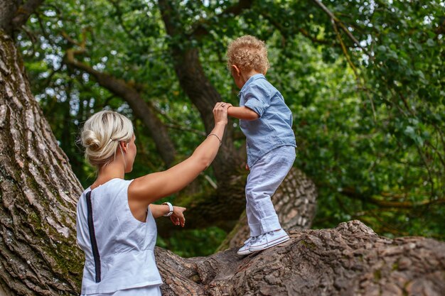 Mother playing with her child on tree in the park.