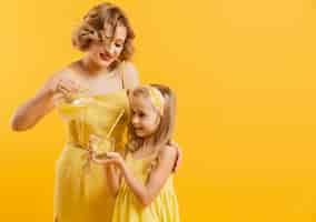 Free photo mother pouring lemonade for daughter