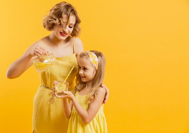 Mother pouring lemonade for daughter