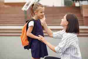 Foto gratuita la madre prepara la piccola figlia a scuola