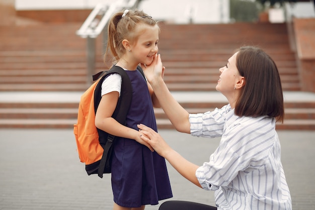 母は小さな娘を学校に準備します