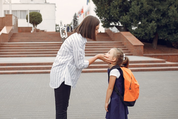 母は小さな娘を学校に準備します