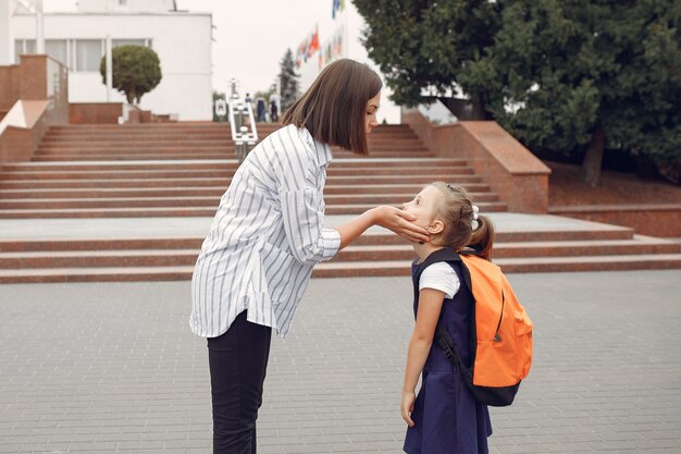 母は小さな娘を学校に準備します