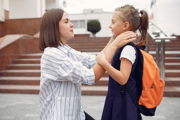 母は小さな娘を学校に準備します