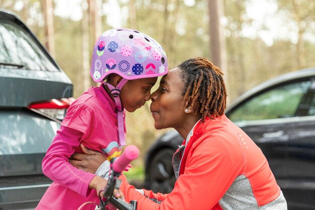 Mother preparing her daughter for a bicycle ride