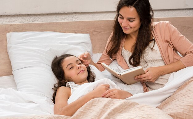 Mother reading a book for her daughter