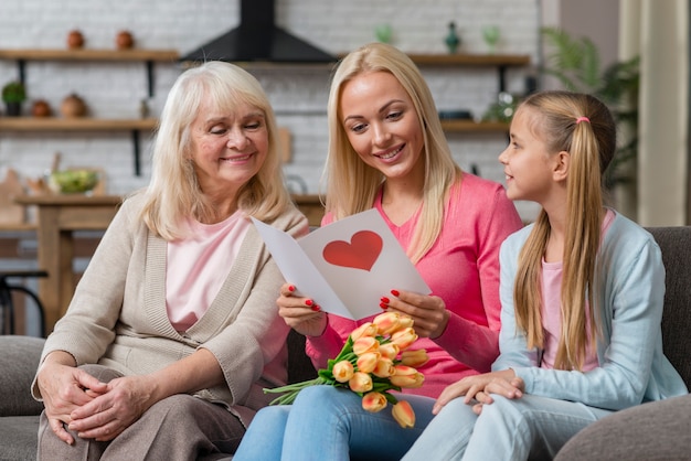 Madre che legge una lettera adorabile mentre sedendosi