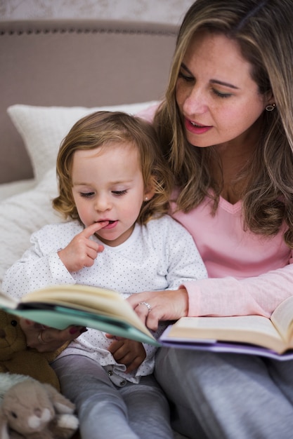 Бесплатное фото Мать читает вместе с дочерью