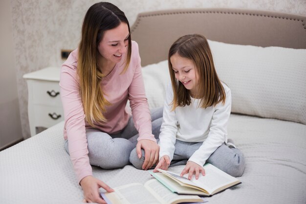 Mother reading together with daughter