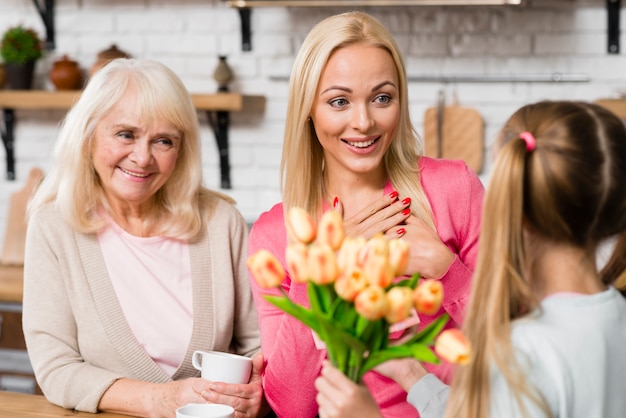 Foto gratuita madre che riceve un mazzo di fiori da sua figlia