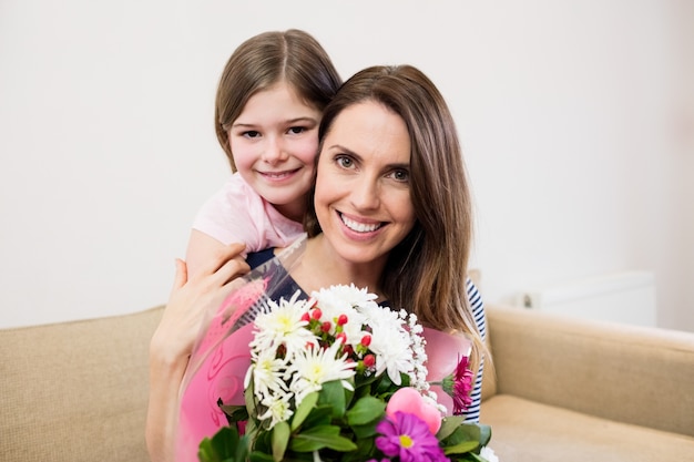 Free photo mother receiving flower bouquet from her daughter