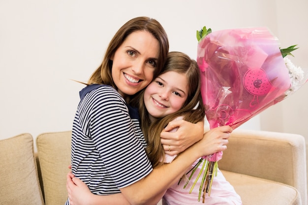 Mother receiving flower bouquet from her daughter