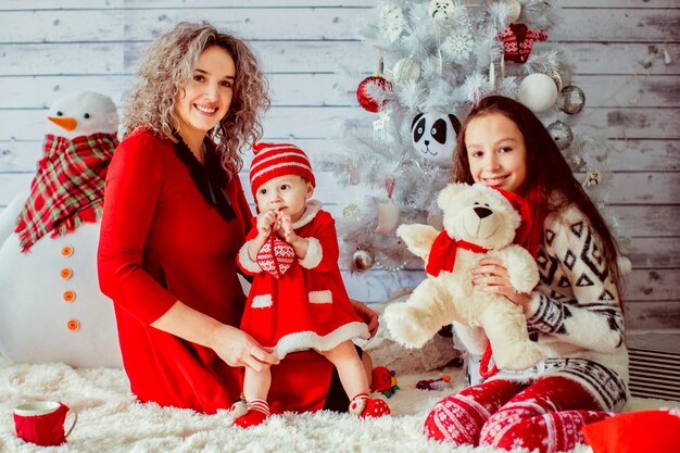 "Mother in red dress with daughters"