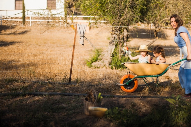 Mother riding her daughters in the wheel barrow