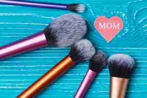 Free photo mother's day background with paper heart and make-up brushes