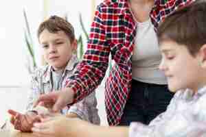 Free photo mother sanitizing her children's hands