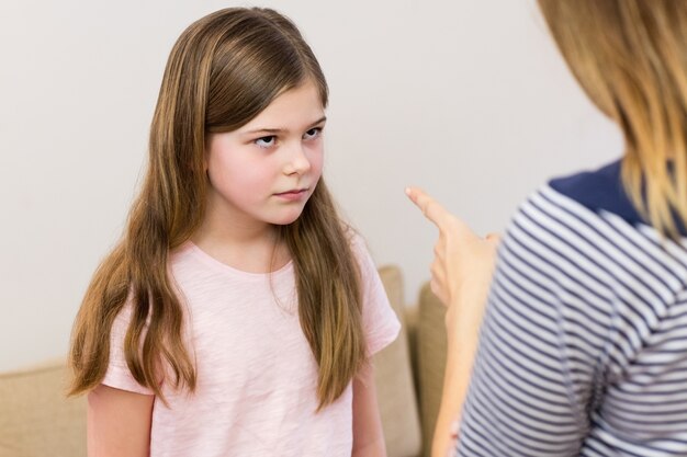 Mother scolding her daughter in living room