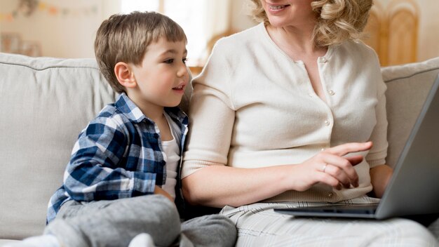 Mother sitting next to her son and working