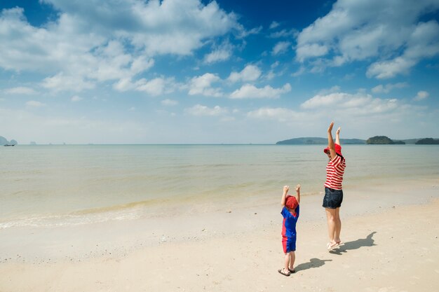 Мать и сын на пляже на открытом воздухе Море и голубое небо