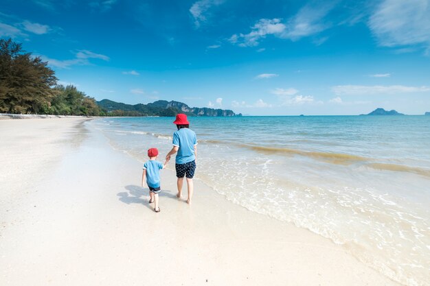 Мать и сын на пляже на открытом воздухе Море и голубое небо
