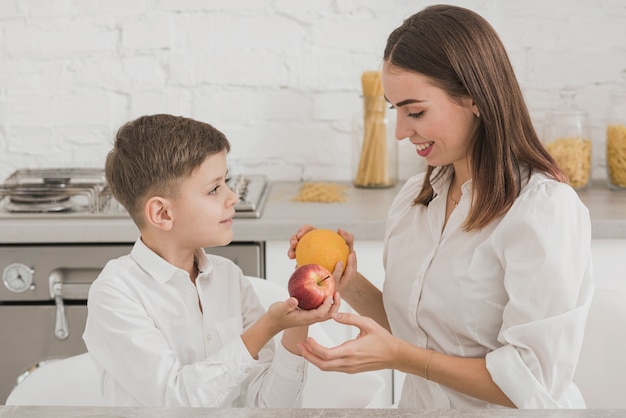 Mother and son holding delicious fruits