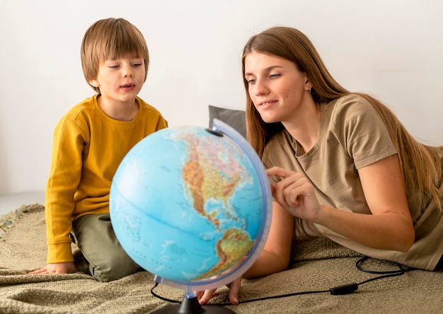 Free photo mother and son looking at globe together