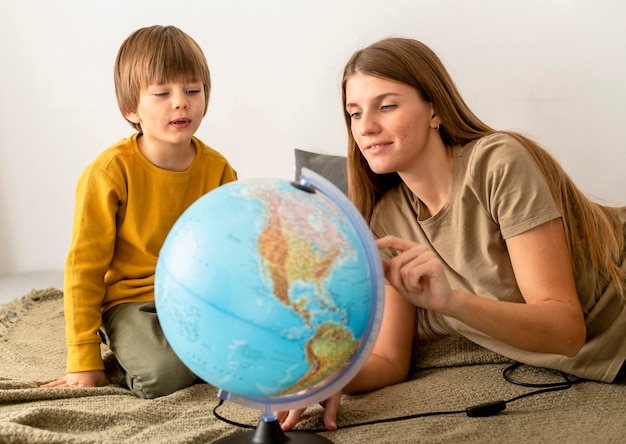 Mother and son looking at globe together