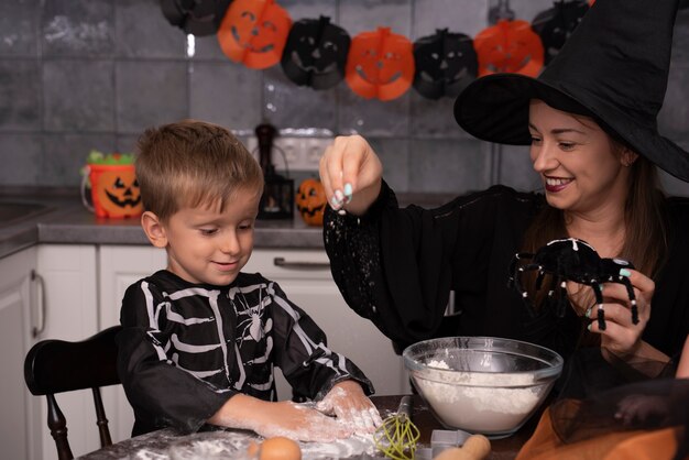 Madre e figlio che producono i biscotti di Halloween