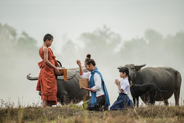 Free photo mother and son offer food to a novice in the meadow.