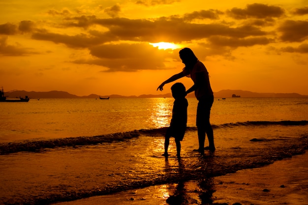 A mother and son in outdoors at sunset with copy space