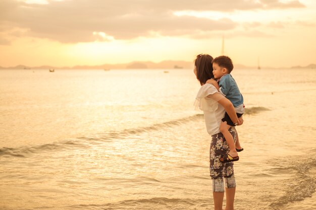 Una madre e un figlio all'aperto al tramonto con spazio di copia