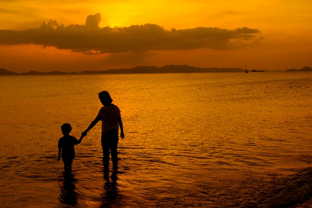 A mother and son in outdoors at sunset with copy space