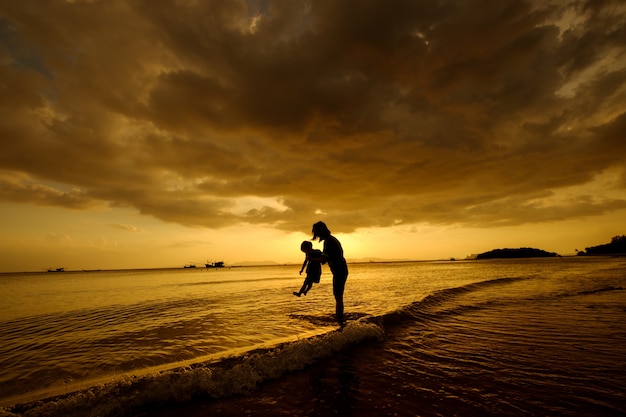 A mother and son in outdoors at sunset with copy space