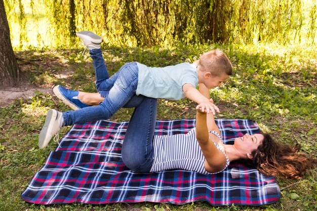 Mother and son playing on picnic blanket