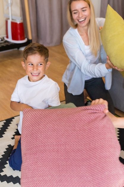 Free photo mother and son playing with pillows