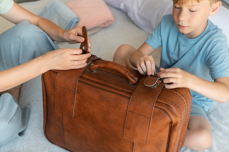 Free Photo mother and son preparing a suitcase for their holiday