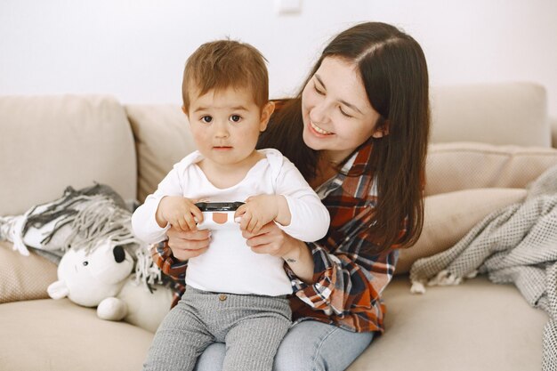 Mother and son sitting together and playing with joystick