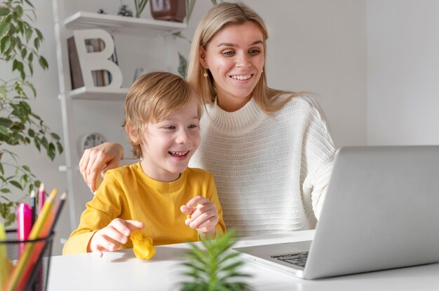 Mother and son using laptop at home