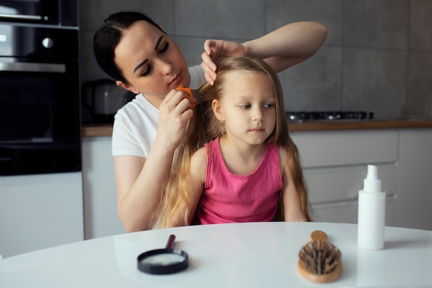 Free photo mother taking care of child with head lices